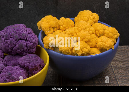 Shredded yellow and purple cauliflower in viole and yellow bowls.Close,horizontal  view. Stock Photo