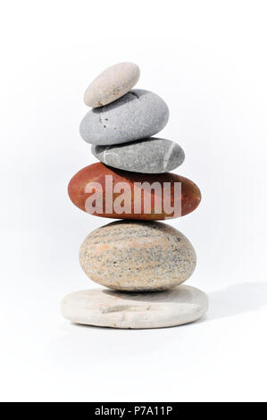 Six stones balancing on each other to create a tower of stones. Image is set against a white background Stock Photo