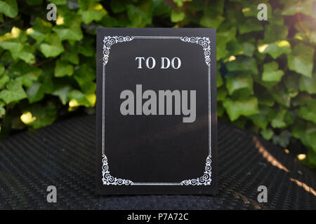 To do list chalkboard with space for own text in green garden in the sunset Stock Photo