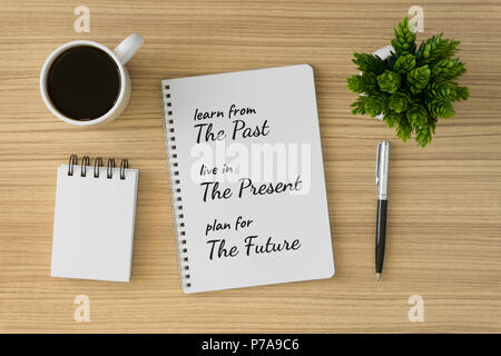 Notebook with motivational and inspirational wisdom quote on wood desk. Learn from the past, live in the present, plan for the future. Stock Photo