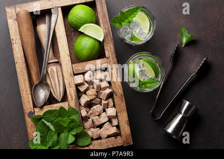 Mojito cocktail and ingredients and bar accessories box on wooden table. Top view Stock Photo