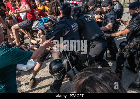 Barcelona, Catalonia, Spain. 5th July, 2018. Protester clash with police who seek to facilitate access to buyers and subaster.The popular mobilization against the public auction of a set of properties corresponding to intestate inheritances has managed to delay the start of the auction scheduled for 10:00 a.m. In spite of the strong popular resistance, the auctioneers and buyers have been accessing the site with the help of the Catalan police Mossos d'Esquadra. Throughout the morning there have been small confrontations between activists and police. (Credit Image: © Paco Freire/SOPA Images vi Stock Photo