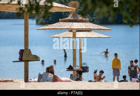 Paderborn, Germany. 03rd July, 2018. People lying on an artificial sandy beach at Lippesee lake. Credit: Friso Gentsch/dpa/Alamy Live News Stock Photo