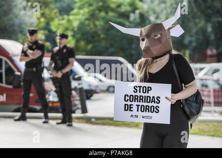 Pamplona, Navarra, Spain. 5th July, 2018. Activist against animal cruelty in bull fightings wears a paperboard bullhead mask near the local police before the San Fermin celebrations, Spain. Banner says ''stop bullfightings' Credit: Celestino Arce/ZUMA Wire/Alamy Live News Stock Photo