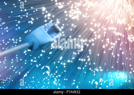Futuristic technological background, closeup on the end of optical fiber network cable on blue background Stock Photo