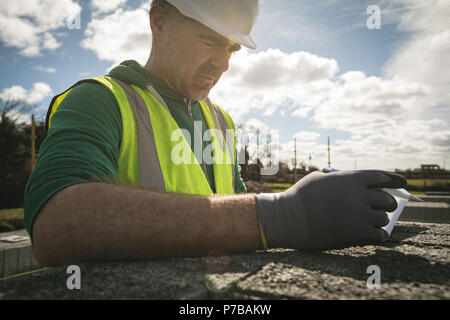 Engineer reading his notes at the construction site Stock Photo