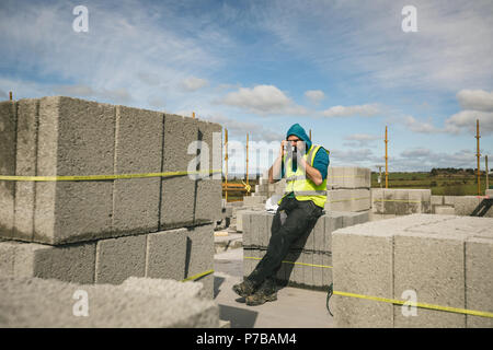 Engineer drinking coffee and talking on the phone Stock Photo