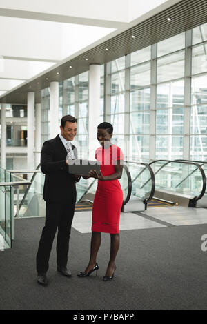 Businessman and businesswoman discussing over a laptop in the office Stock Photo