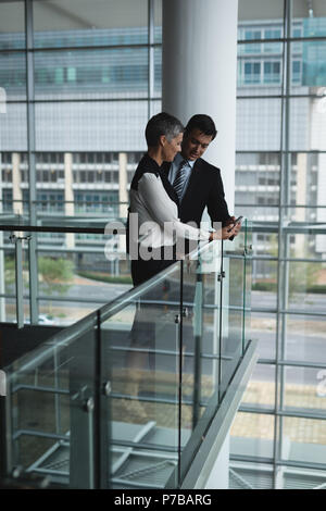Businessman and businesswoman having a discussion over the mobile phone Stock Photo