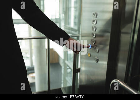 Businessperson pressing a button in the elevator Stock Photo