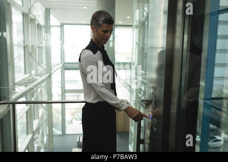 Businesswoman pressing a button in the elevator Stock Photo
