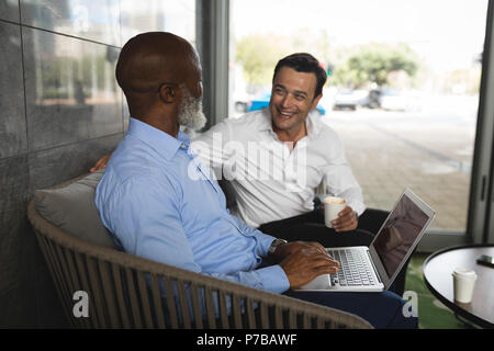 Businessmen smiling while working on laptop Stock Photo