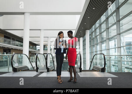 Businesswomen discussing over the digital tablet in office Stock Photo