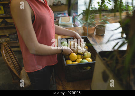 Young woman removing vegetable from the tray Stock Photo