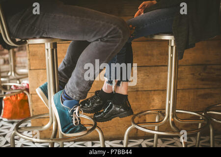 Legs of couple sitting at bar counter Stock Photo