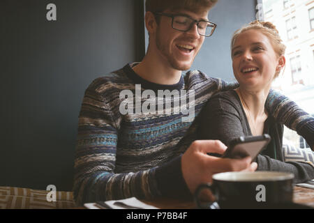 Couple using mobile phone in the cafe Stock Photo