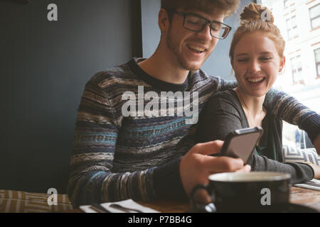 Couple using mobile phone in the cafe Stock Photo