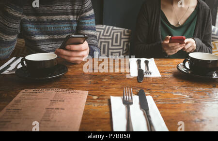 Couple using mobile phones in the cafe Stock Photo