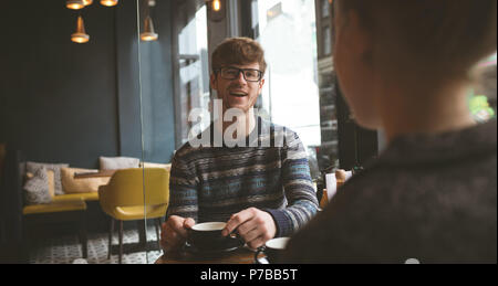Smiling man talking to woman in cafe Stock Photo