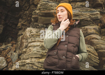 Female hiker leaning against the rock Stock Photo