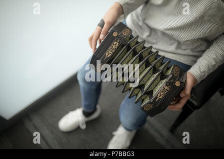 Schoolgirl playing accordion in music school Stock Photo