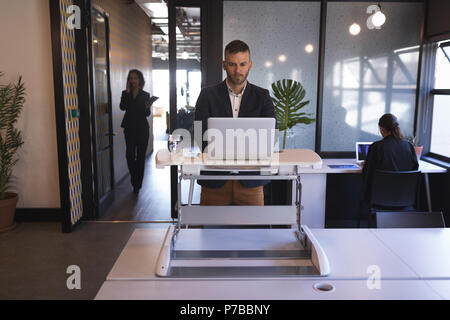 Businessman standing and using laptop Stock Photo