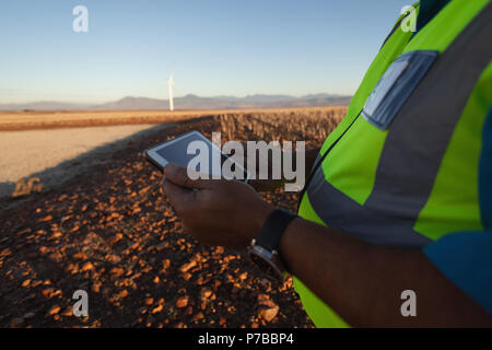 Engineer using a tablet at wind farm Stock Photo