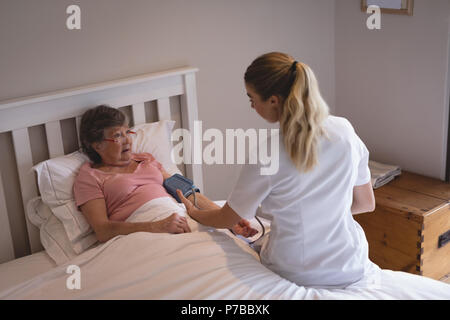 Physiotherapist checking blood pressure of senior woman Stock Photo