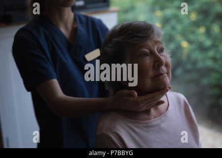 Physiotherapist giving a neck massage to senior woman Stock Photo