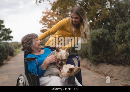 Granddaughter taking grandmother out for a walk Stock Photo