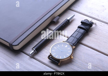Men's accessories for business and rekreation. Leather notebook, watch and pen on wood background.. Top view composition. Stock Photo