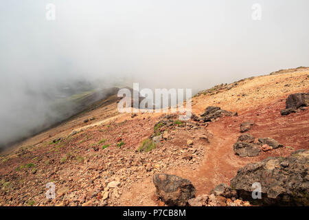Red earth and volcanic rocks on Mt. Asahi in Hokkaido, Japan Stock Photo