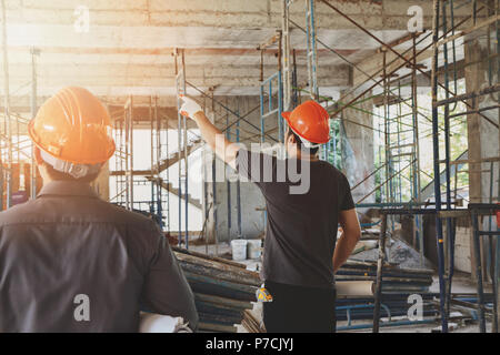 Engineer discussing with foreman about project in building construction site Stock Photo