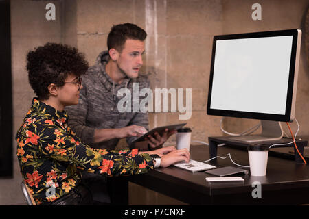 Male and female executive working on computer at desk Stock Photo
