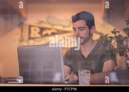 Man using laptop in cafe Stock Photo