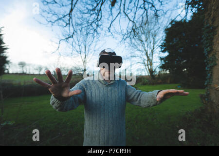 Man using virtual reality headset in forest Stock Photo