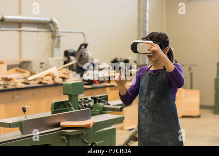 Female carpenter using virtual reality headset Stock Photo