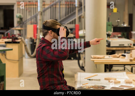 Male carpenter using virtual reality headset Stock Photo