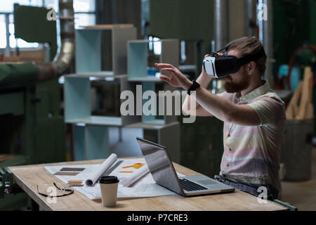 Male carpenter using virtual reality headset Stock Photo