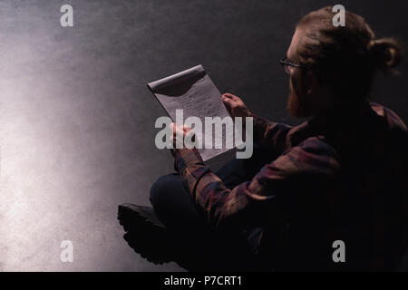 Male actor reading script on stage Stock Photo
