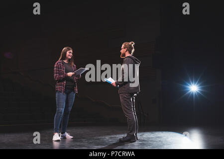 Male and female actress reading script on stage Stock Photo