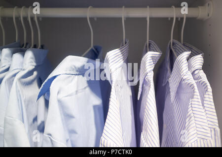 Business striped and smooth shirts hanging in a closet Stock Photo