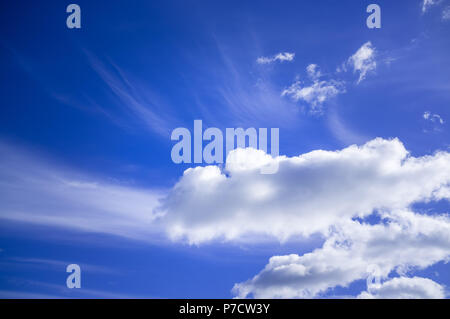 Blue sky with white fluffy clouds on bright sunny day Stock Photo