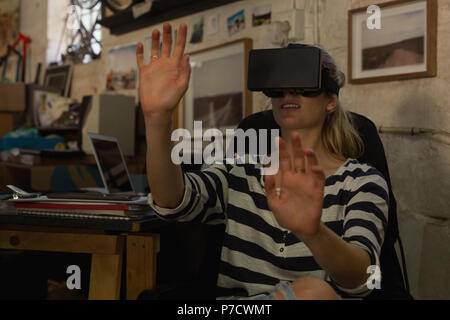 Female mechanic using virtual reality headset in workshop Stock Photo