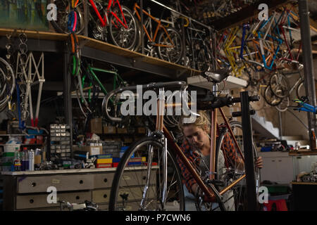 Female mechanic examining a bicycle Stock Photo