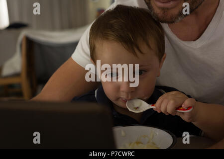 Father and son having breakfast while using digital tablet Stock Photo