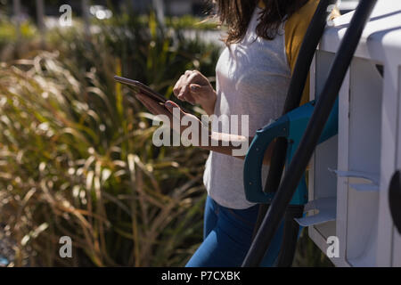 Woman using digital tablet at charging station Stock Photo