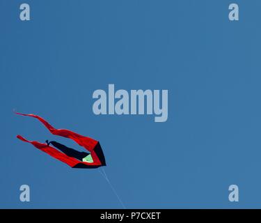 Red kite flying in a clear blue sky Stock Photo