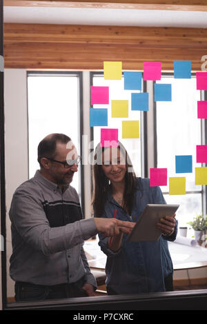 Business colleagues discussing over digital tablet Stock Photo