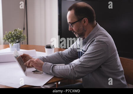 Male executive using digital tablet at desk Stock Photo